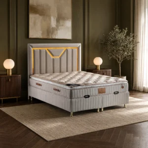 Doppelbett mit sandfarbenem Kopfteil und goldener Zierlinie vor einer dunkelgrünen Wand